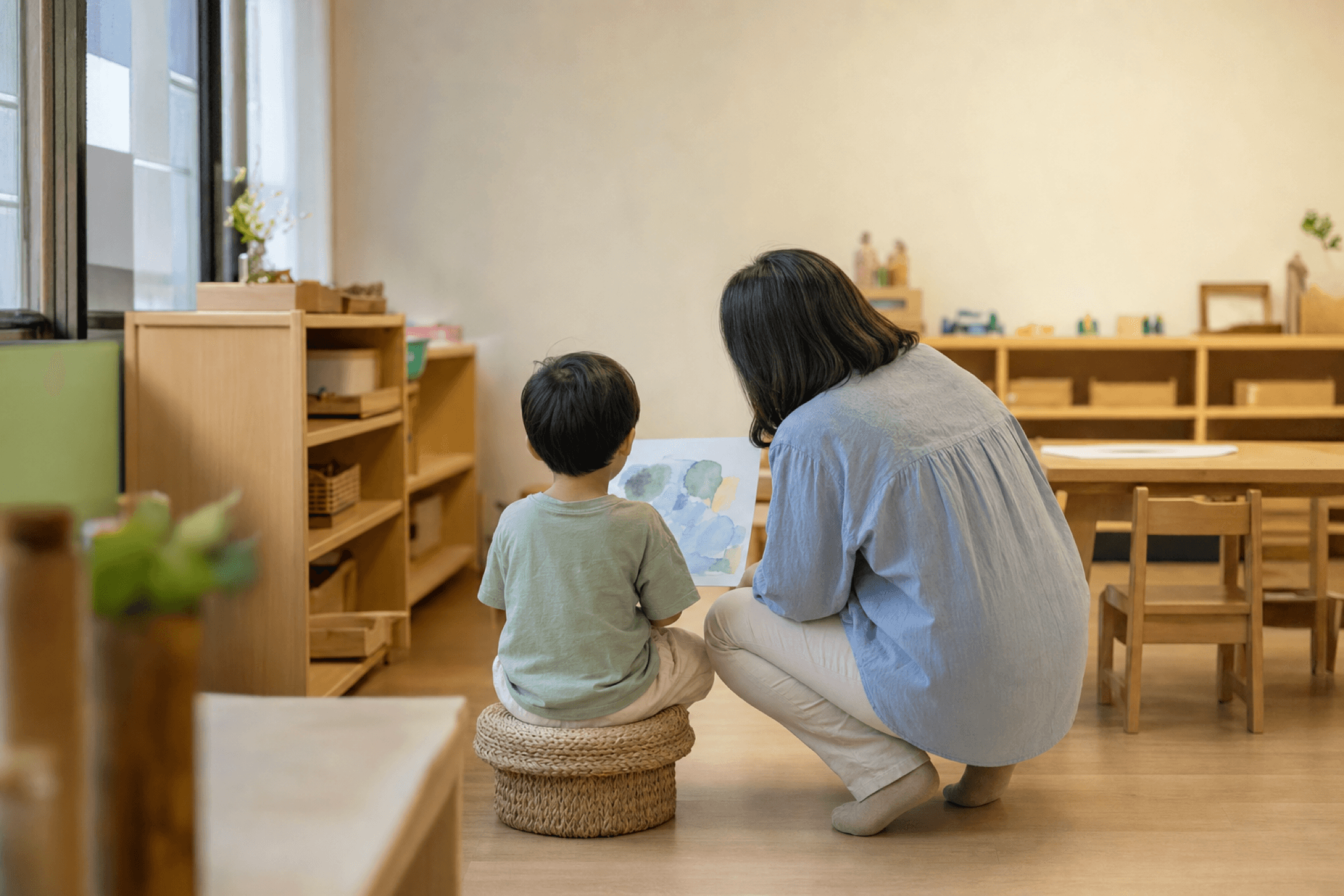 老師與孩子一起看作品的示意照片